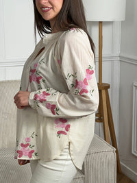 Confectionnée dans une matière légère et légèrement transparente, elle offre confort et élégance au quotidien. Ses manches longues et son col rond classique se complètent parfaitement avec des boutons discrets sur toute la longueur. Les motifs fleurs roses et vertes apportent une touche de douceur et de féminité à cette chemise polyvalente, idéale pour créer des looks décontractés ou plus raffinés selon vos envies.