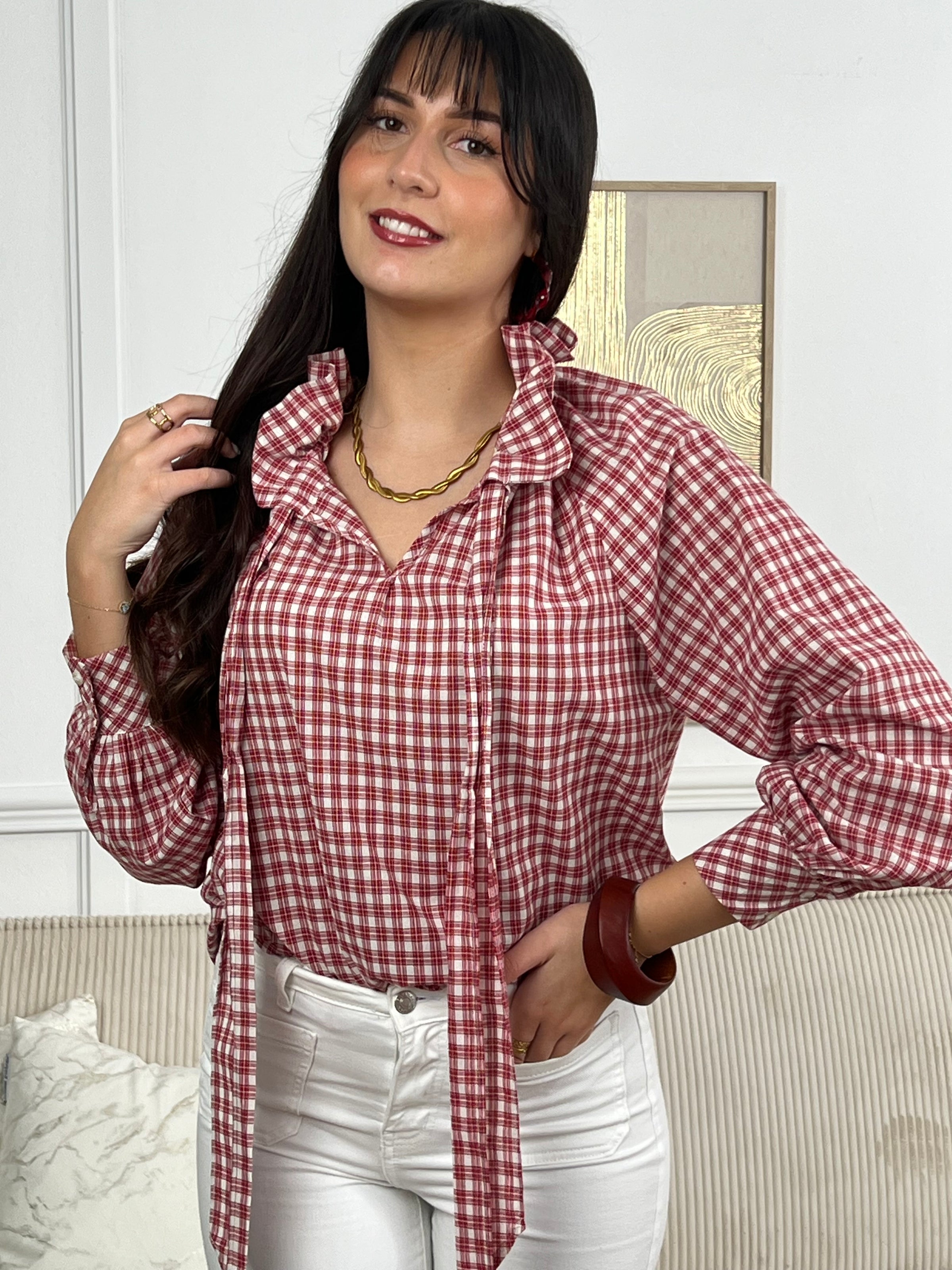 Découvrez la Dahlia, une chemise intemporelle qui allie élégance et confort. Confectionnée en rouge et écrue, elle séduira par son col V orné de volants ajustables et ses manches longues. Le motif carreaux apporte une touche de caractère à cette pièce polyvalente.