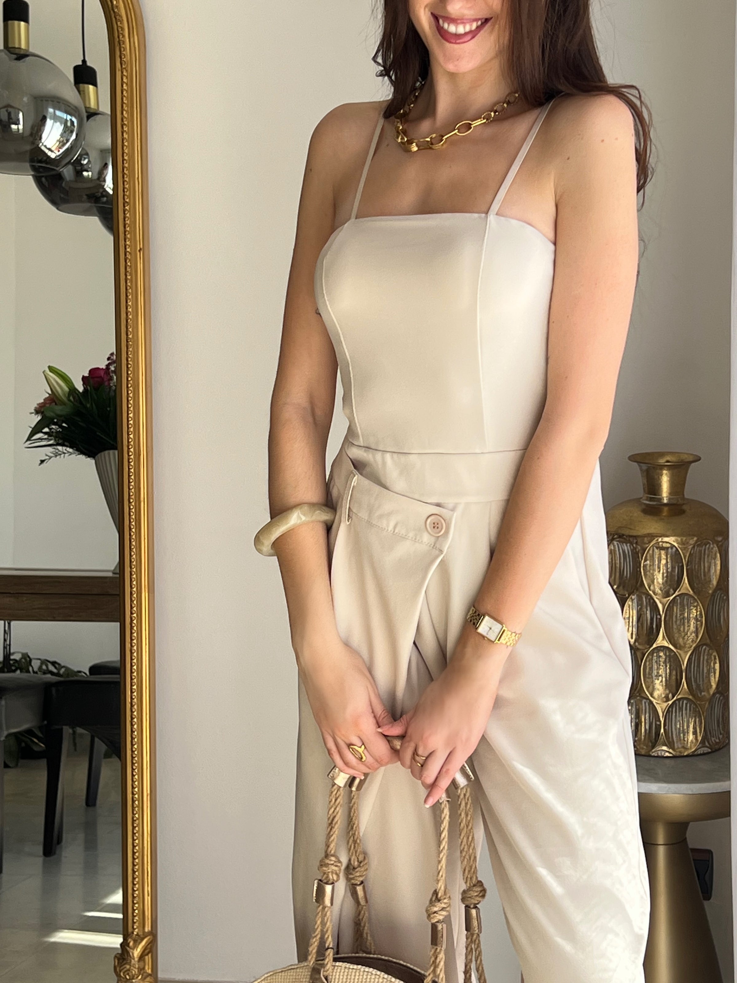 Combinaison beige femme élégante au style moderne, dotée de bretelles réglables et d’un bustier qui sublime la silhouette. Sa coupe asymétrique sur le devant apporte une touche originale et tendance. Pratique avec ses poches latérales et confortable grâce à son élastique au dos, elle est idéale pour un look chic et facile à porter.