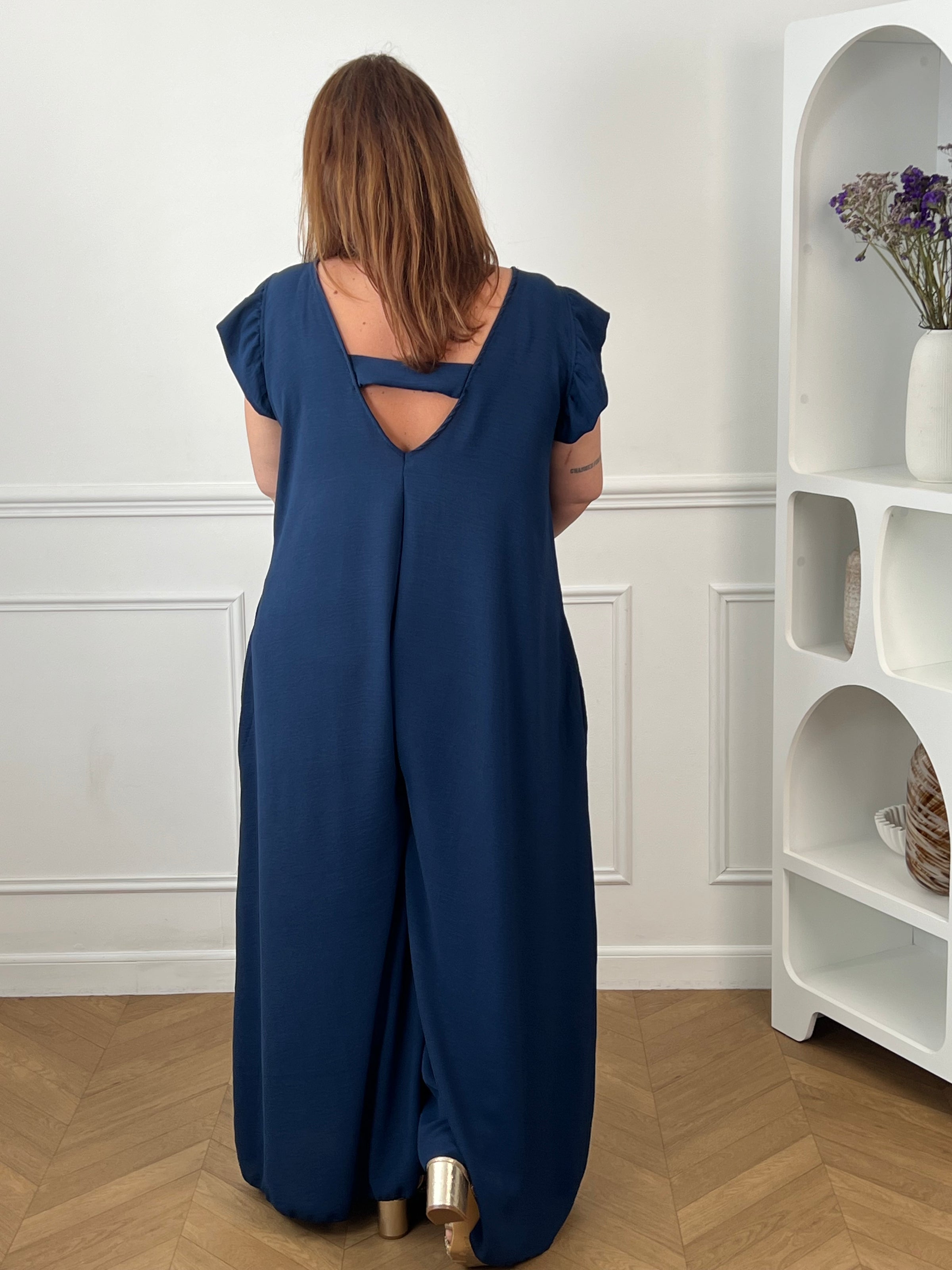 Combinaison longue et ample bleue à la coupe fluide et élégante. Une pièce confortable et féminine, parfaite pour une allure chic et effortless en toute occasion.