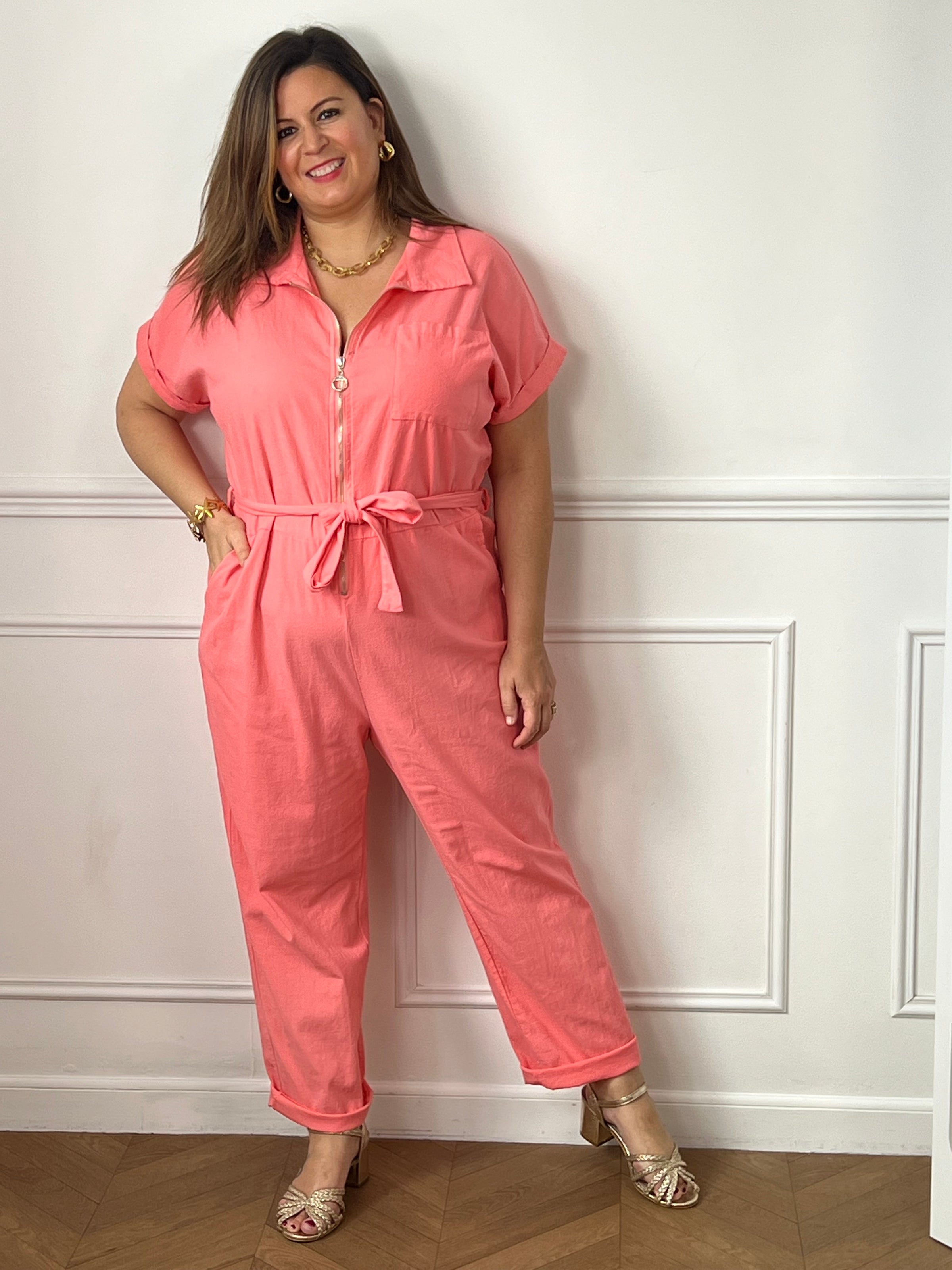 Adoptez un look tendance et confortable avec cette combinaison corail grande taille femme. Sa coupe fluide et ses manches courtes offrent une grande liberté de mouvement, tandis que son col chemise et sa fermeture zippée sur le devant apportent une touche moderne et élégante. Dotée d’une ceinture amovible pour souligner la taille, de deux poches latérales et d’une poche poitrine pratique, cette combinaison corail est la pièce idéale pour un style chic et décontracté au quotidien.