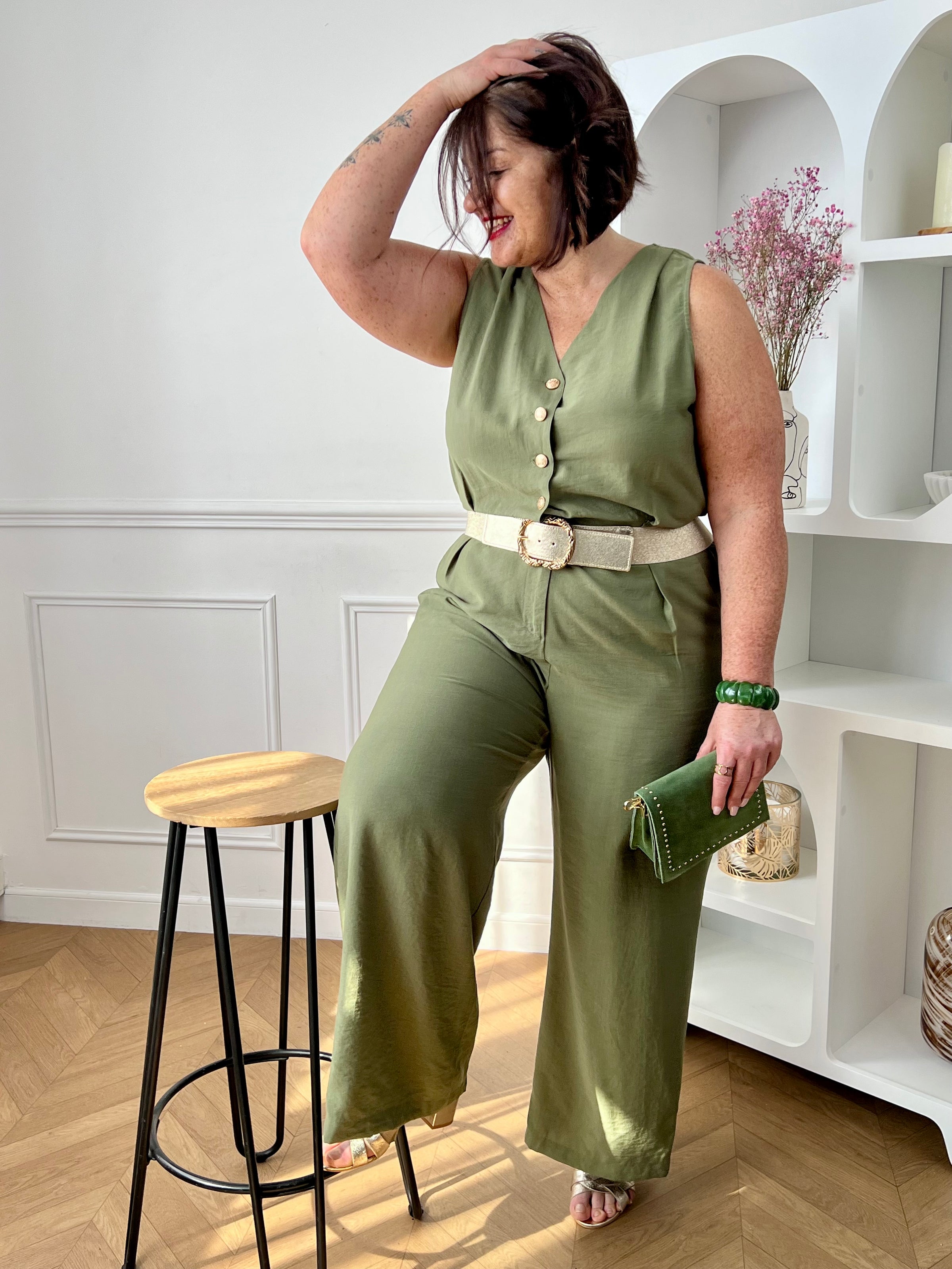 Combinaison longue femme, élégante et moderne, parfaite pour un look tendance au quotidien. Sans manches, avec un col V et des boutons dorés sur le haut, elle apporte une touche chic et raffinée. Dotée d’une ceinture amovible avec passants et d’une taille élastique au dos, elle assure un ajustement confortable. Ses deux poches latérales et sa fermeture zippée à l’avant allient praticité et style.