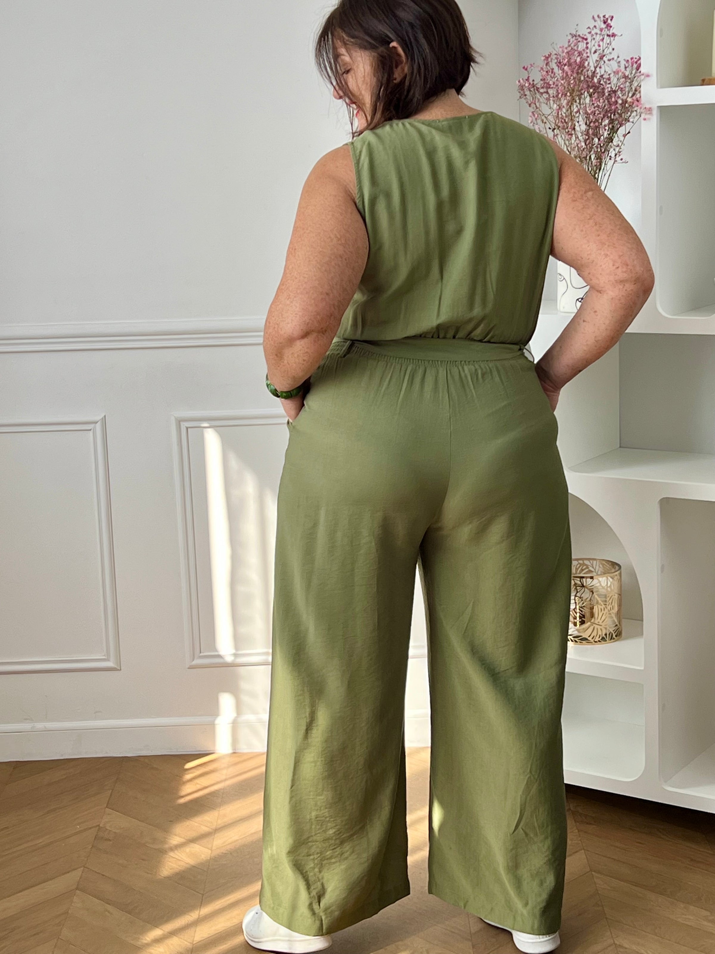 Combinaison longue femme, élégante et moderne, parfaite pour un look tendance au quotidien. Sans manches, avec un col V et des boutons dorés sur le haut, elle apporte une touche chic et raffinée. Dotée d’une ceinture amovible avec passants et d’une taille élastique au dos, elle assure un ajustement confortable. Ses deux poches latérales et sa fermeture zippée à l’avant allient praticité et style.