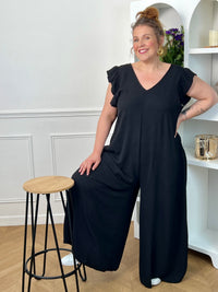 Combinaison longue et ample noire à la coupe fluide et élégante. Une pièce confortable et féminine, parfaite pour une allure chic et effortless en toute occasion.