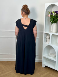Combinaison longue et ample noire à la coupe fluide et élégante. Une pièce confortable et féminine, parfaite pour une allure chic et effortless en toute occasion.