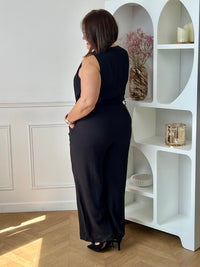 Combinaison longue femme, élégante et moderne, parfaite pour un look tendance au quotidien. Sans manches, avec un col V et des boutons dorés sur le haut, elle apporte une touche chic et raffinée. Dotée d’une ceinture amovible avec passants et d’une taille élastique au dos, elle assure un ajustement confortable. Ses deux poches latérales et sa fermeture zippée à l’avant allient praticité et style.