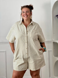 Idéal pour un look casual et confortable. Doté d’un col chemise, de manches courtes et d’une coupe ample, il offre une silhouette moderne et décontractée. Avec sa poche poitrine, ses deux poches latérales et ses boutons jusqu’à mi-longueur, il allie style et praticité. Confectionné en 100% coton, ce combishort beige à rayures est parfait pour une tenue tendance au quotidien.