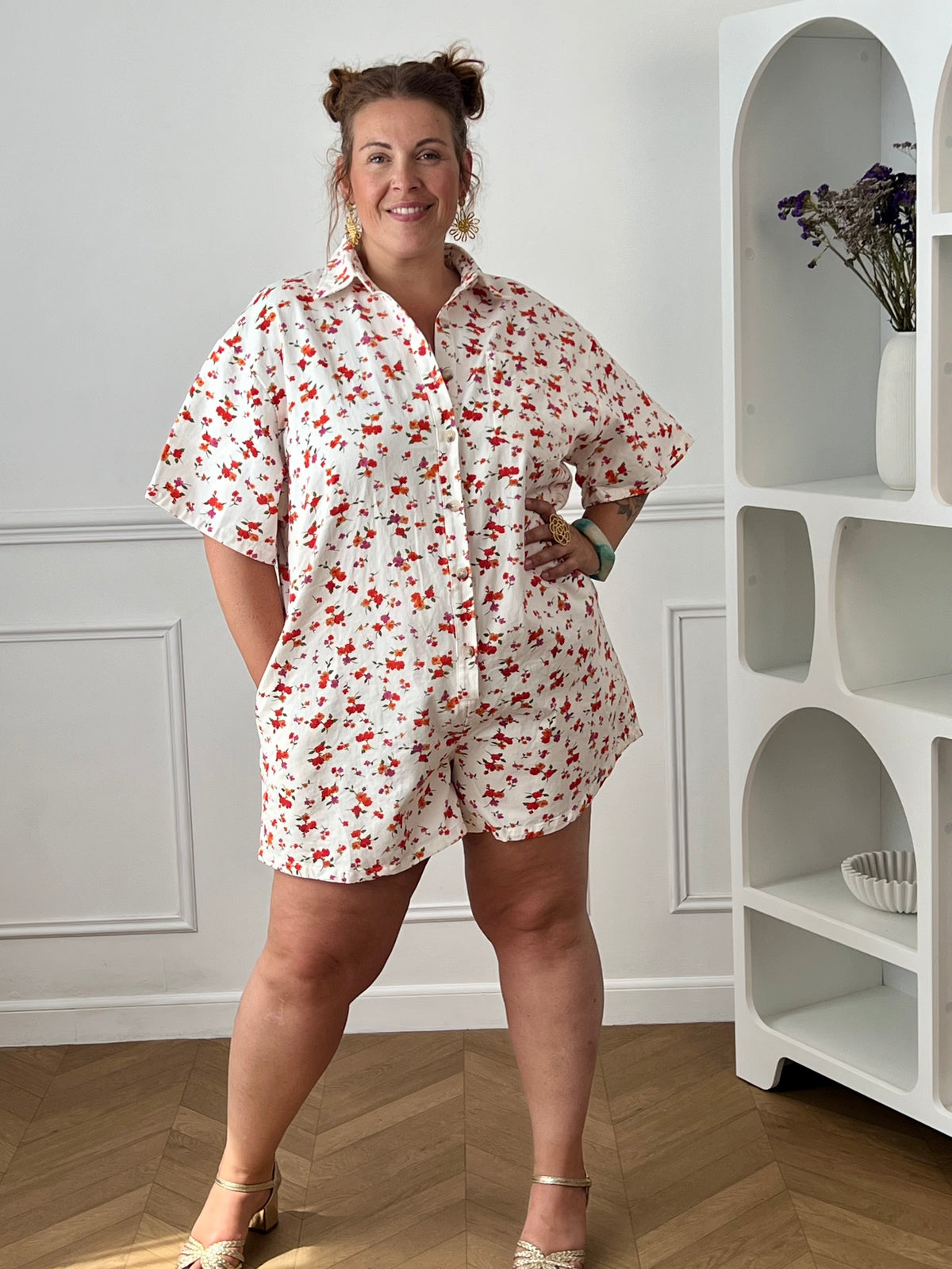 Craquez pour ce combishort grande taille au style à la fois tendance et confortable. Sa coupe ample, son col chemise et ses manches courtes en font une pièce idéale pour les journées ensoleillées. Doté d'une poche poitrine, de deux poches latérales pratiques et de boutons jusqu'à mi-longueur, il allie style et fonctionnalité. Ses motifs fleuris aux nuances d'écru, rouge, orange, vert et violet apportent une touche de fraîcheur et de féminité à vos tenues estivales.