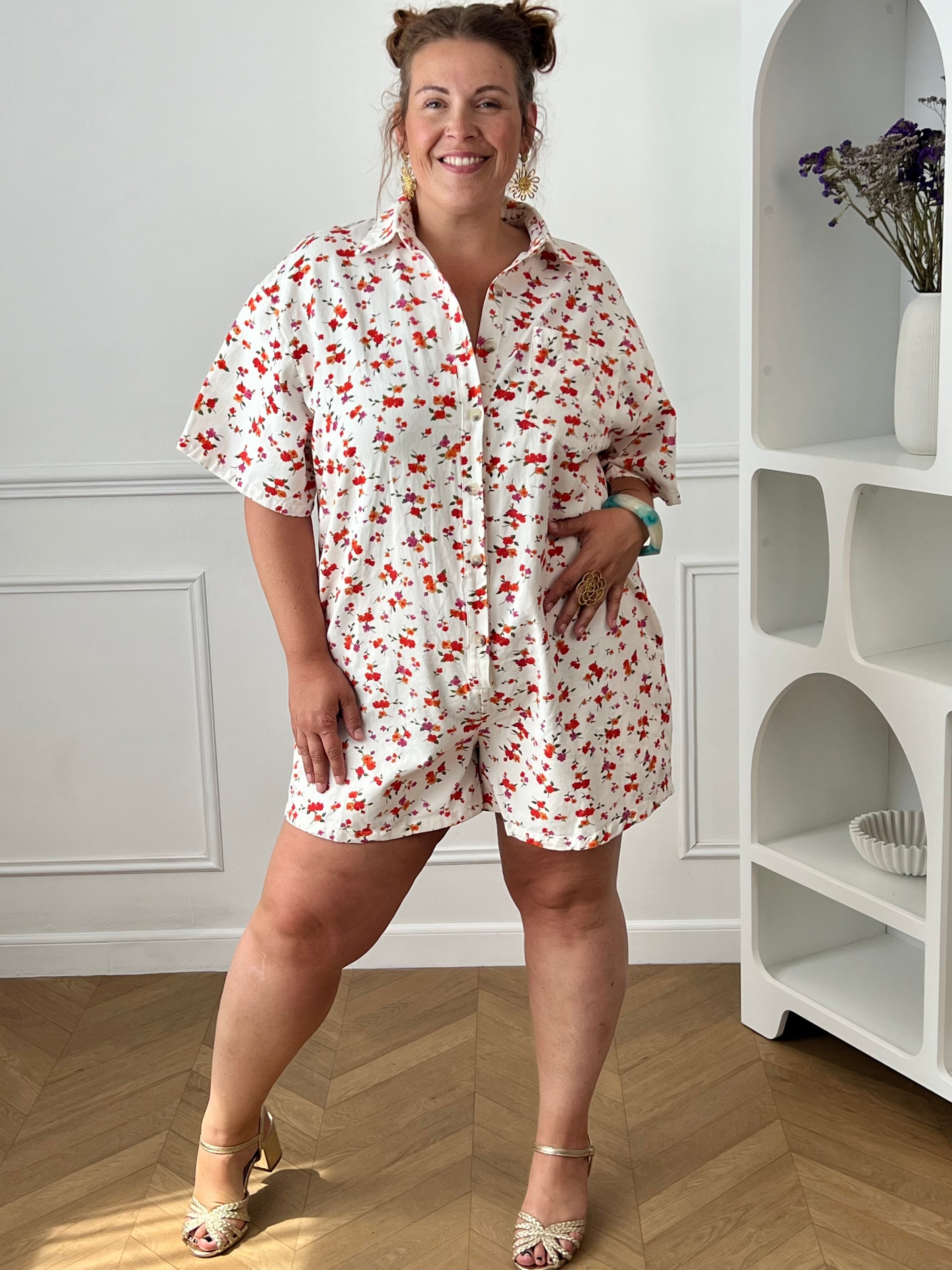 Craquez pour ce combishort grande taille au style à la fois tendance et confortable. Sa coupe ample, son col chemise et ses manches courtes en font une pièce idéale pour les journées ensoleillées. Doté d'une poche poitrine, de deux poches latérales pratiques et de boutons jusqu'à mi-longueur, il allie style et fonctionnalité. Ses motifs fleuris aux nuances d'écru, rouge, orange, vert et violet apportent une touche de fraîcheur et de féminité à vos tenues estivales.