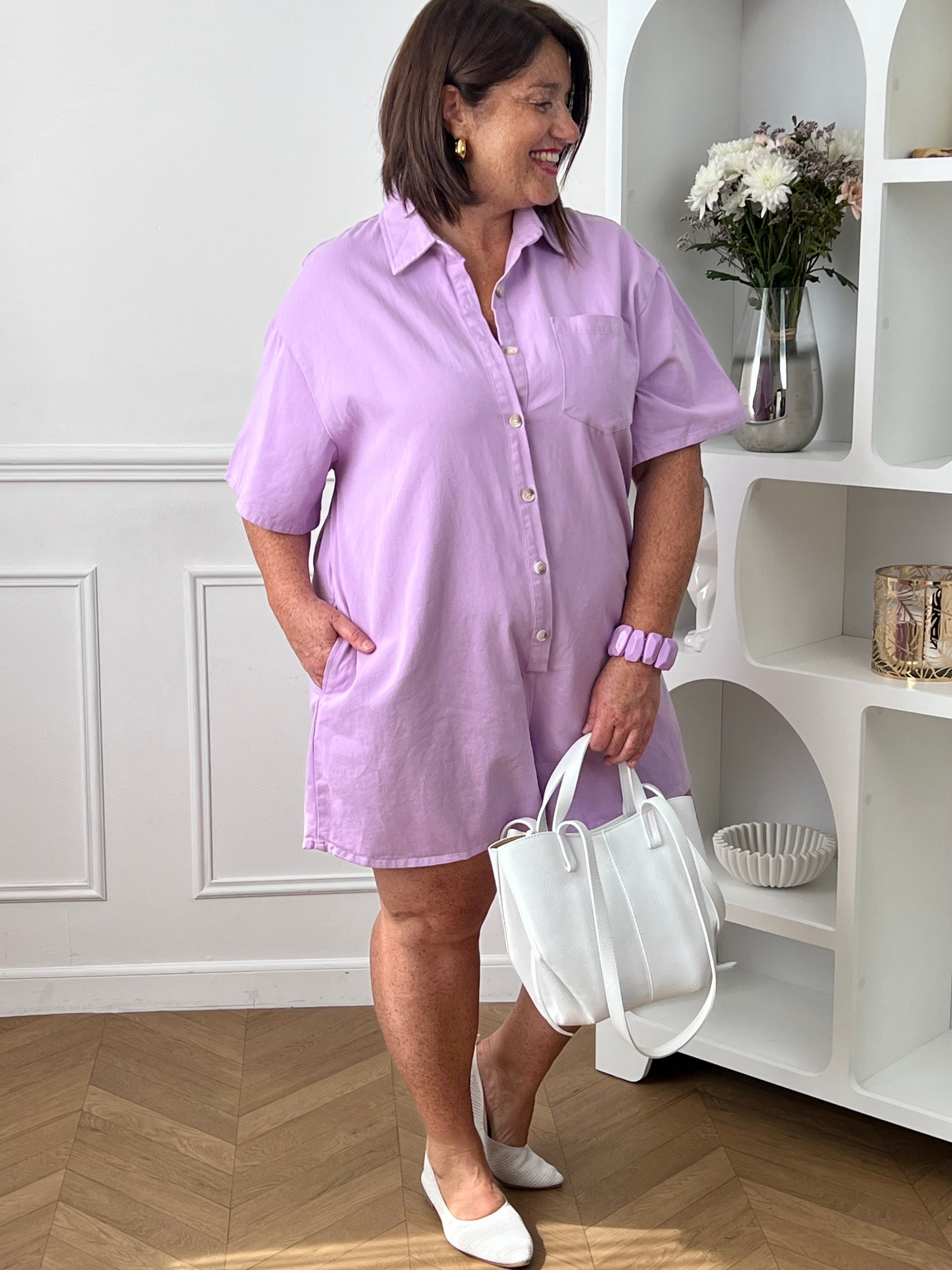 Idéal pour un look casual et confortable. Doté d’un col chemise, de manches courtes et d’une coupe ample, il offre une silhouette moderne et décontractée. Avec sa poche poitrine, ses deux poches latérales et ses boutons jusqu’à mi-longueur, il allie style et praticité. Confectionné en 100% coton, ce combishort lilas est parfait pour une tenue tendance au quotidien.