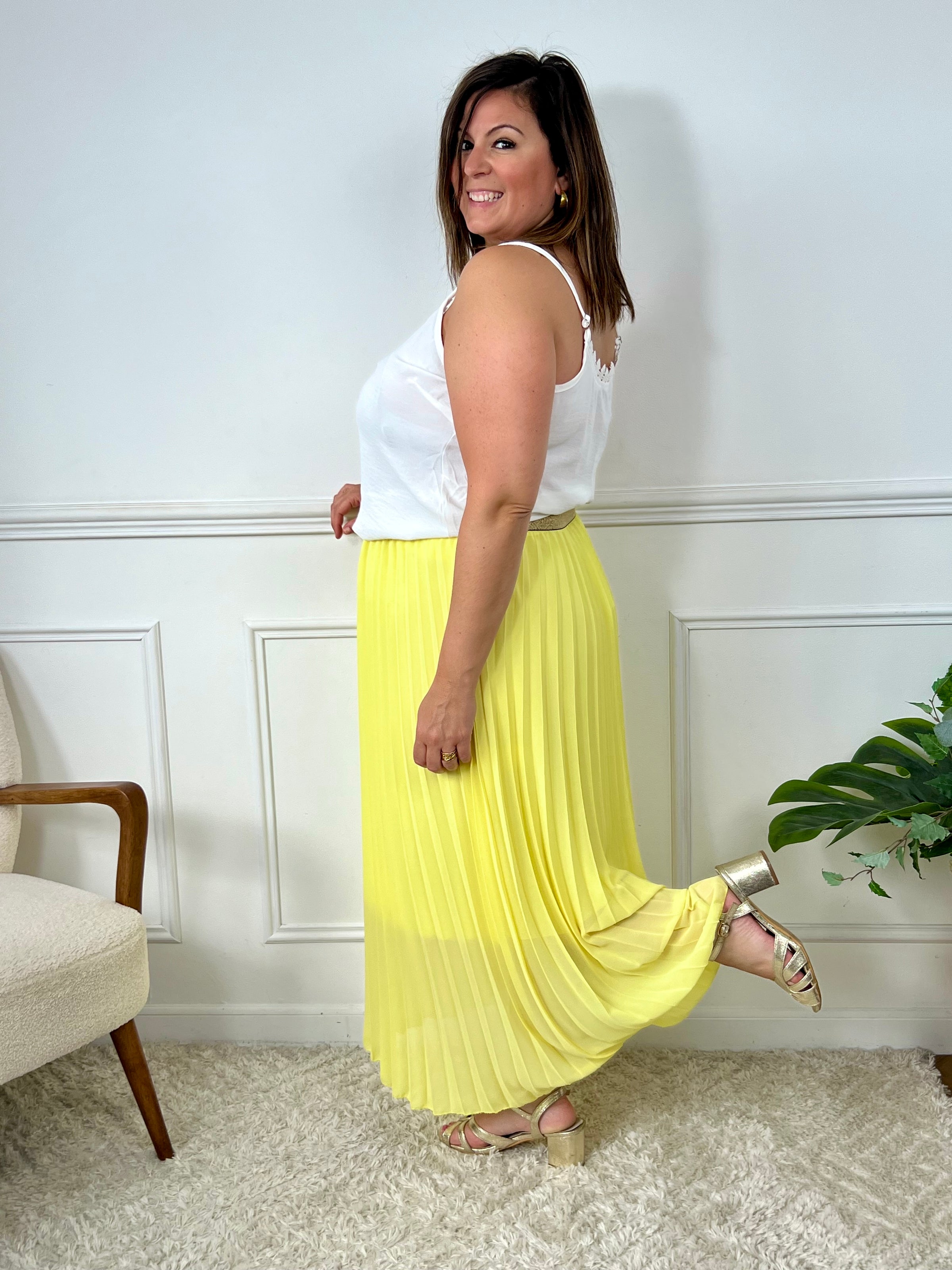 La jupe jaune plissée de grande taille incarne une élégance intemporelle. Avec sa coupe longue et plissée, elle offre une silhouette flatteuse et tendance. Cette pièce allie style et confort, créant une tenue sophistiquée et moderne pour les femmes de grande taille.