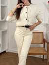 Ce gilet beige Eloisa allie élégance et féminité avec ses manches longues et son col rond délicatement agrémenté de volants. La ligne de boutons noirs, ornés de détails dorés et d’une perle, apporte une touche raffinée qui souligne subtilement la silhouette.