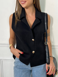 Ce gilet sans manches noir est un incontournable pour une allure sophistiquée et tendance. Avec son col chemise et ses boutons dorés sur la longueur, il ajoute une touche chic à vos tenues. Facile à porter seul ou en superposition, il se marie parfaitement avec une chemise blanche pour un look classique, ou un top ajusté pour une allure plus moderne.