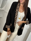 Ce blazer noir, nommé Axella, allie élégance et originalité. Ses manches longues et ses deux poches factices sur le devant offrent une silhouette structurée, tandis que le détail léopard qui court le long des poches et des revers de manches apporte une touche audacieuse et moderne.