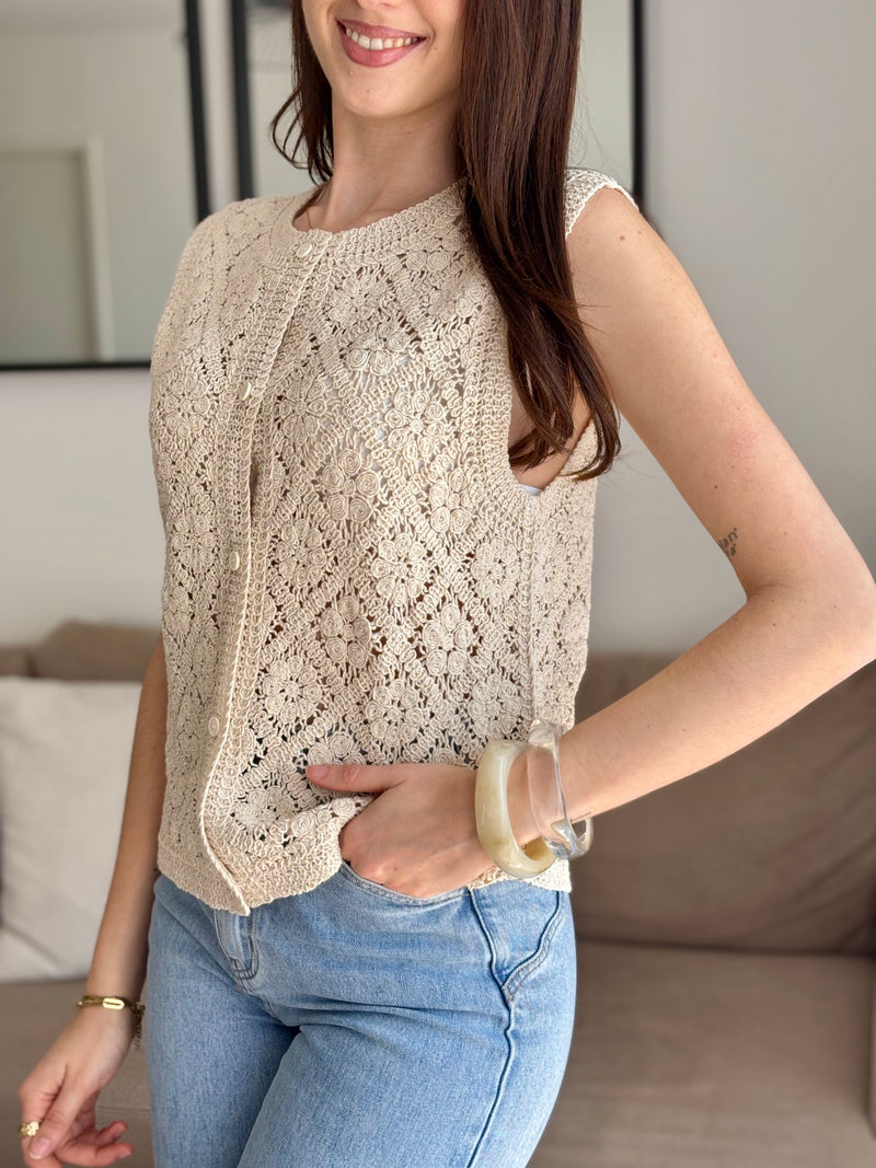 Rejoignez la tendance du crochet avec le top sans manches Liyah ! Avec son col rond et ses boutons sur la longueur, ce top apporte une touche vintage et bohème à votre garde-robe.