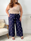 On craque pour ce pantalon bleu marine fluide et raffiné, habillé de délicats motifs palmier beige. Idéal pour un look à la fois chic et dépaysant, parfait en toute saison.
