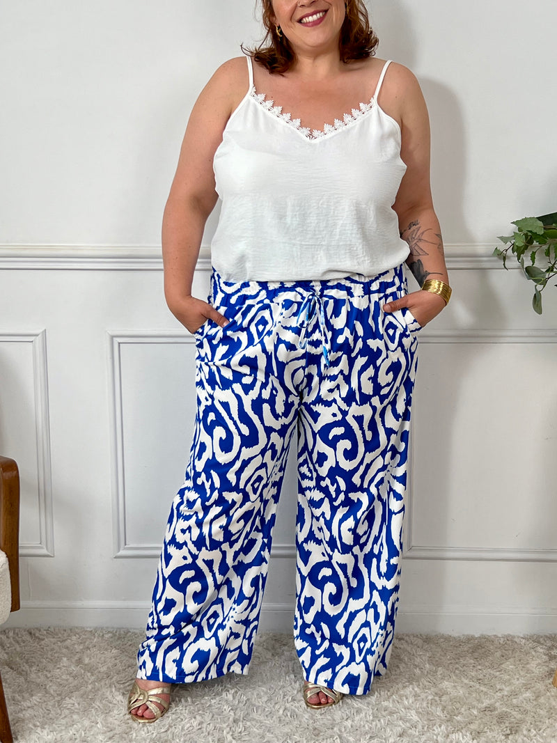 Sublimez votre silhouette avec le pantalon Linzy, une pièce audacieuse en bleu ornée de motifs élégants. Sa coupe ample célèbre vos courbes tout en garantissant un confort optimal pour toutes les occasions.