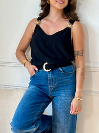 Ce top noir au design épuré séduit par ses bretelles ornées de délicats détails dorés. À la fois sobre et raffiné, il apporte une touche d’élégance à vos looks, de jour comme de nuit.