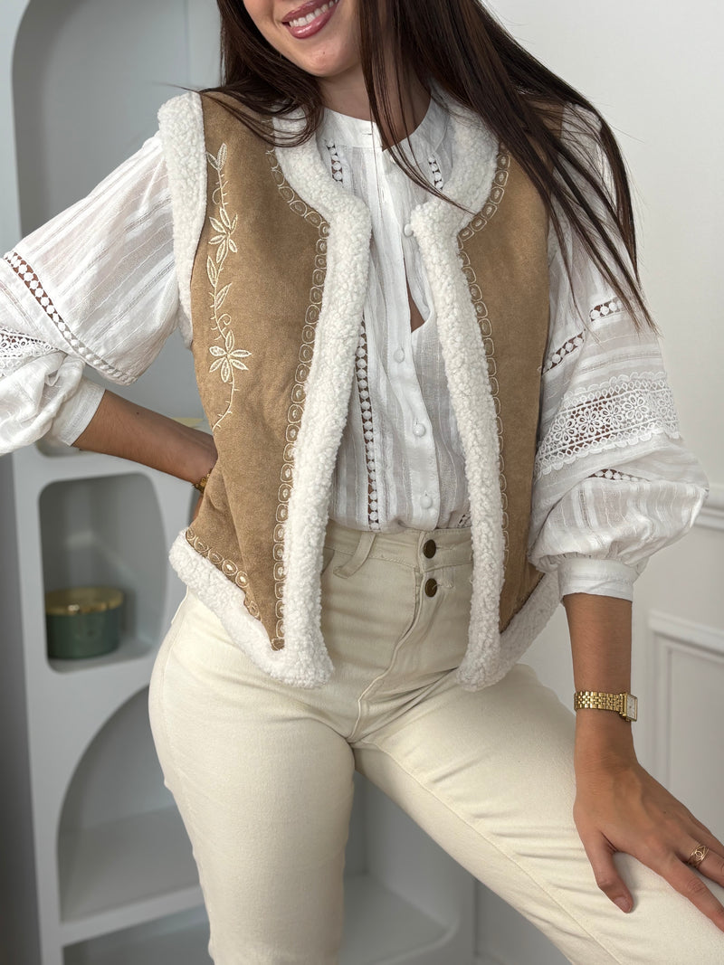 Cette veste sans manches camel Maelia combine douceur et style avec sa moumoute chaleureuse et son col rond confortable. Les motifs floraux apportent une touche féminine et délicate, idéale pour rehausser vos tenues tout en restant confortable.