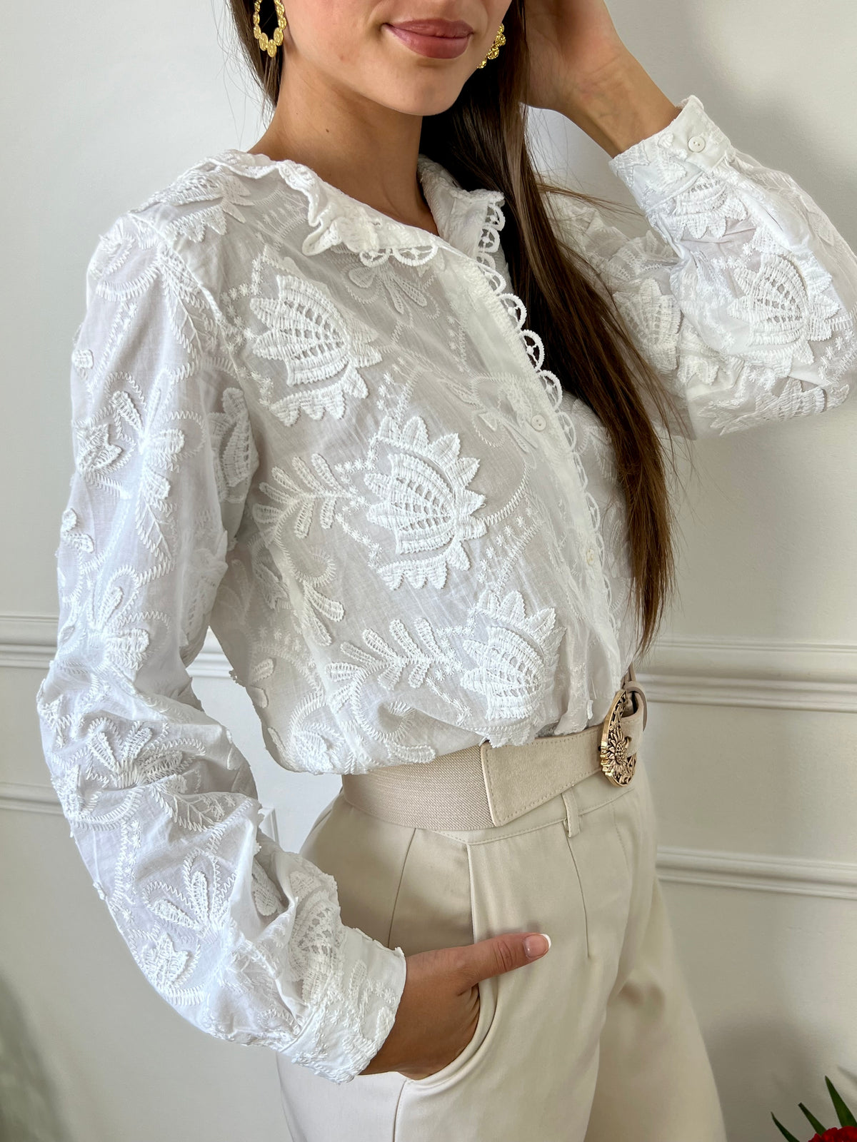 Cette chemise écrue élégante se distingue par ses délicates broderies et son col festonné, ajoutant une touche de raffinement et de féminité. Idéale pour un look chic et romantique, elle se prête parfaitement à des occasions spéciales ou à un style quotidien sophistiqué.