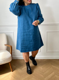 Robe en jean grande taille femme au style casual chic. Col rond et coupe droite moderne, idéale au quotidien comme en sortie. Détails raffinés : boutons dorés aux poignets et à l’épaule. Bleu intemporel, 100% coton pour allier confort et élégance.