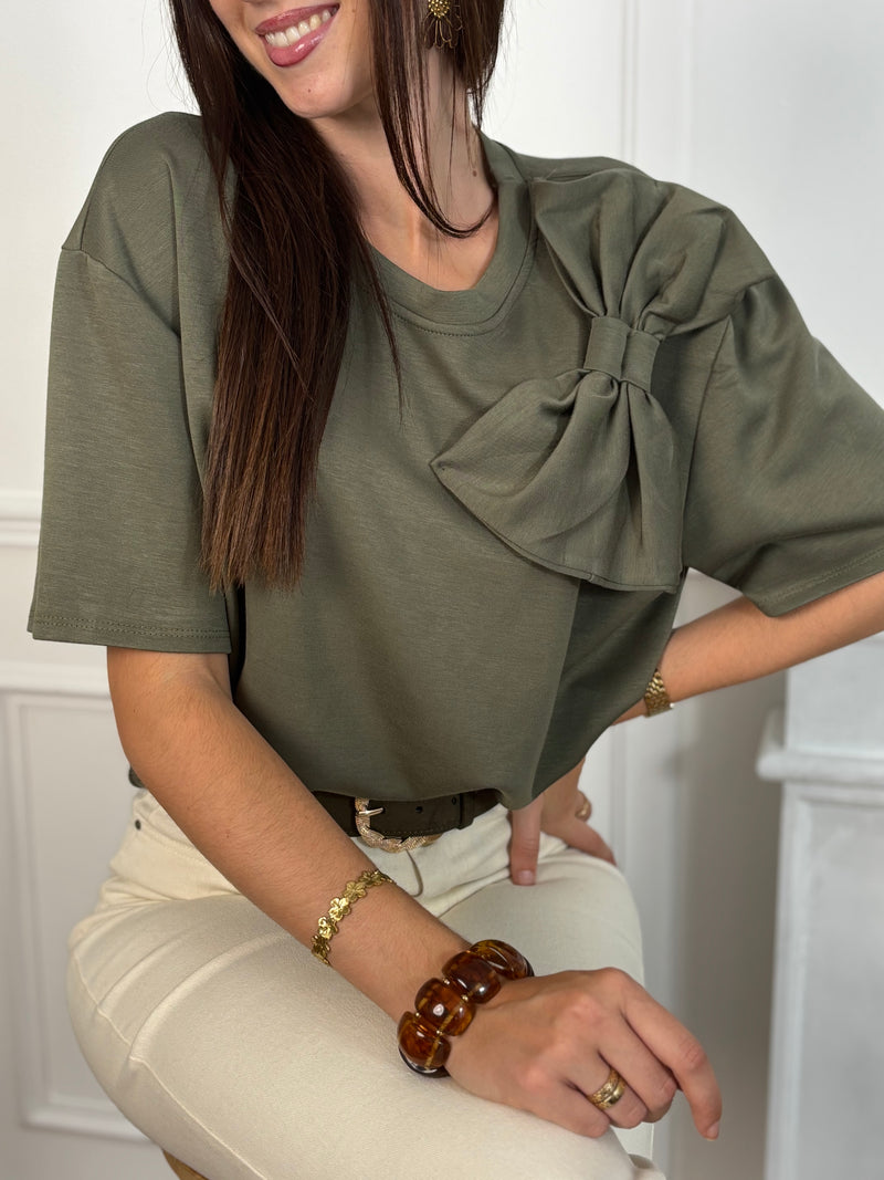 Tee-shirt kaki pour femme, ce tee-shirt à manches courtes est doté d’un col rond et d’un nœud sur le devant pour une touche féminine. Confectionné dans une matière épaisse pour un tombé structuré. Couleur bordeaux, idéale pour la mi-saison.