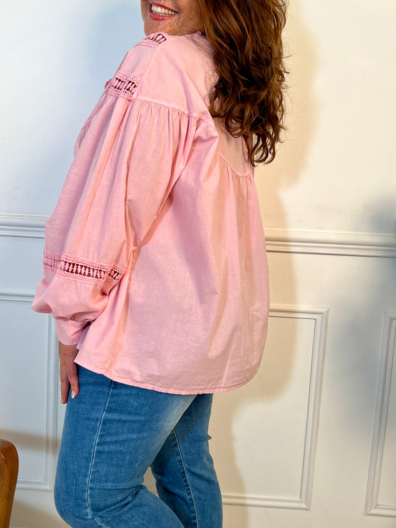 Cette chemise rose manches longues Angelina est à la fois élégante et pleine d'esprit. Parfaite pour ajouter une touche de fantaisie à votre tenue avec ses boutons et broderies uniques sur le devant et aux manches.