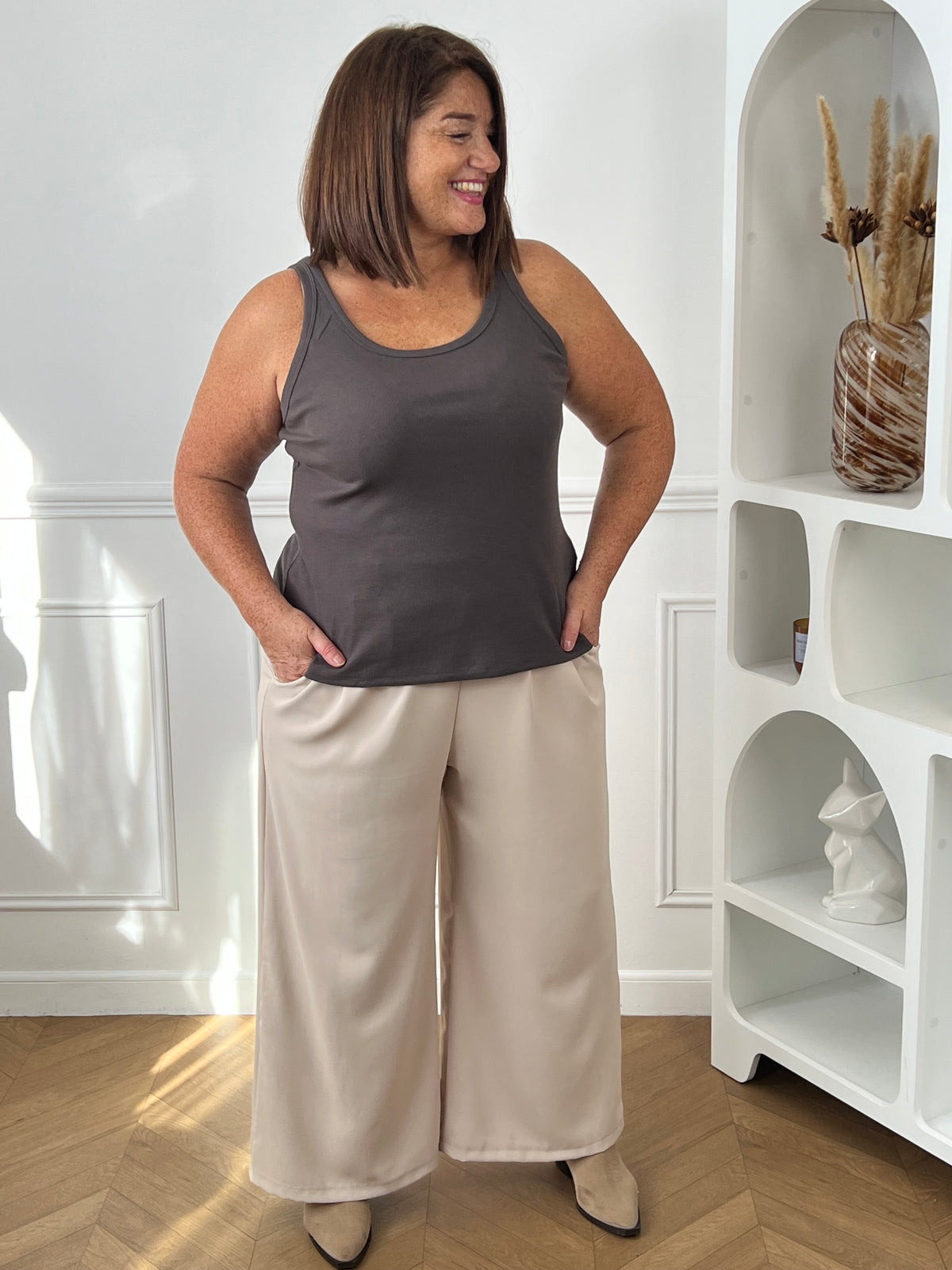 Débardeur gris foncé grande taille porté de face sur un pantalon écru, montrant sa longueur sur les hanches – Dean | Loïcia