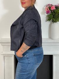 Ce perfecto bleu marine grande taille, modèle Calista, allie élégance et confort. Ses manches longues et son col revers apportent une touche classique, tandis que la fermeture éclair et les boutons argentés ajoutent un détail raffiné.