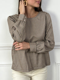 Un incontournable à ajouter à votre dressing ! Cette blouse à carreaux, avec son col V élégant et ses manches longues, offre une allure moderne et féminine. La fente subtile sur le devant, accompagnée de ses boutons raffinés au niveau du décolleté et des poignets, lui donne une touche de caractère. Idéale pour une tenue chic et décontractée, elle s'accorde aussi bien avec un jean qu'une jupe crayon