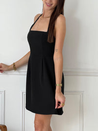Courte et sans manches, elle met en valeur votre silhouette avec un col carré et un dos nu osé. La fermeture éclair au dos ajoute une touche de modernité. Osez en noir pour un look audacieux !