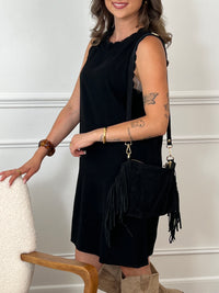 La robe courte noire Floriane est sans manches, avec un col rond devant et derrière. Ses détails festonnés et son ouverture dos avec lien à nouer ajoutent une touche délicate et féminine.