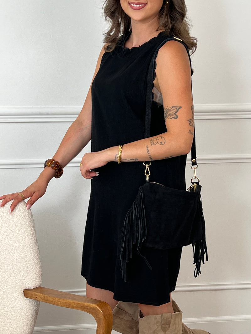 La robe courte noire Floriane est sans manches, avec un col rond devant et derrière. Ses détails festonnés et son ouverture dos avec lien à nouer ajoutent une touche délicate et féminine.