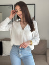 Délicate blouse Solène en gaze de coton écru, ornée de broderies élégantes aux épaules et aux manches. Son col V et ses manches longues apportent une touche de féminité intemporelle. Confectionnée en 100% coton, elle allie légèreté et confort pour sublimer votre silhouette avec raffinement.