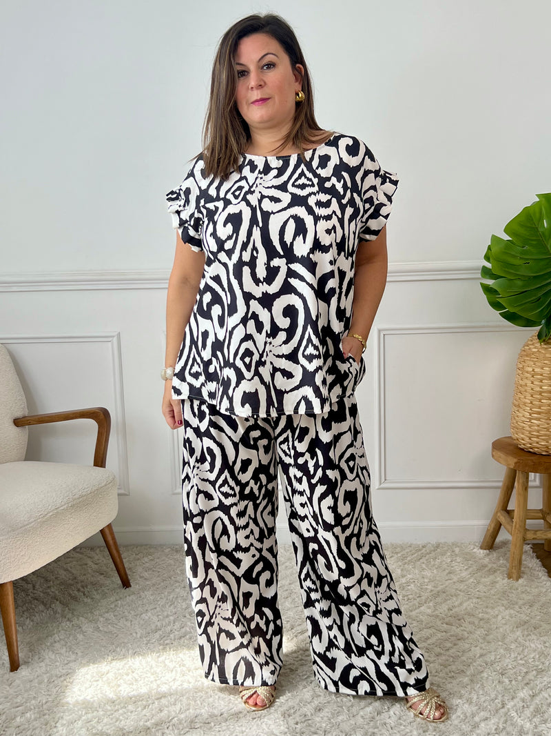 Léger et éclatant, ce top fluide noir et écru sans manches séduit par ses jolis volants aux épaules. Une pièce pleine de fraîcheur et de féminité, parfaite pour égayer vos looks avec une touche raffinée.