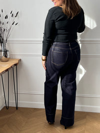 Jean bleu foncé intemporel au style affirmé. Coupe large et confortable avec jambes évasées pour une silhouette moderne. Doté de 4 poches pratiques et de détails dorés aux poches qui ajoutent une touche d'élégance.