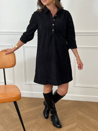 Cette robe courte noire, modèle Cora, allie élégance et confort. Ses manches longues et son col chemise apportent une touche sophistiquée, tandis que les boutons au col et aux manches accentuent son style raffiné.