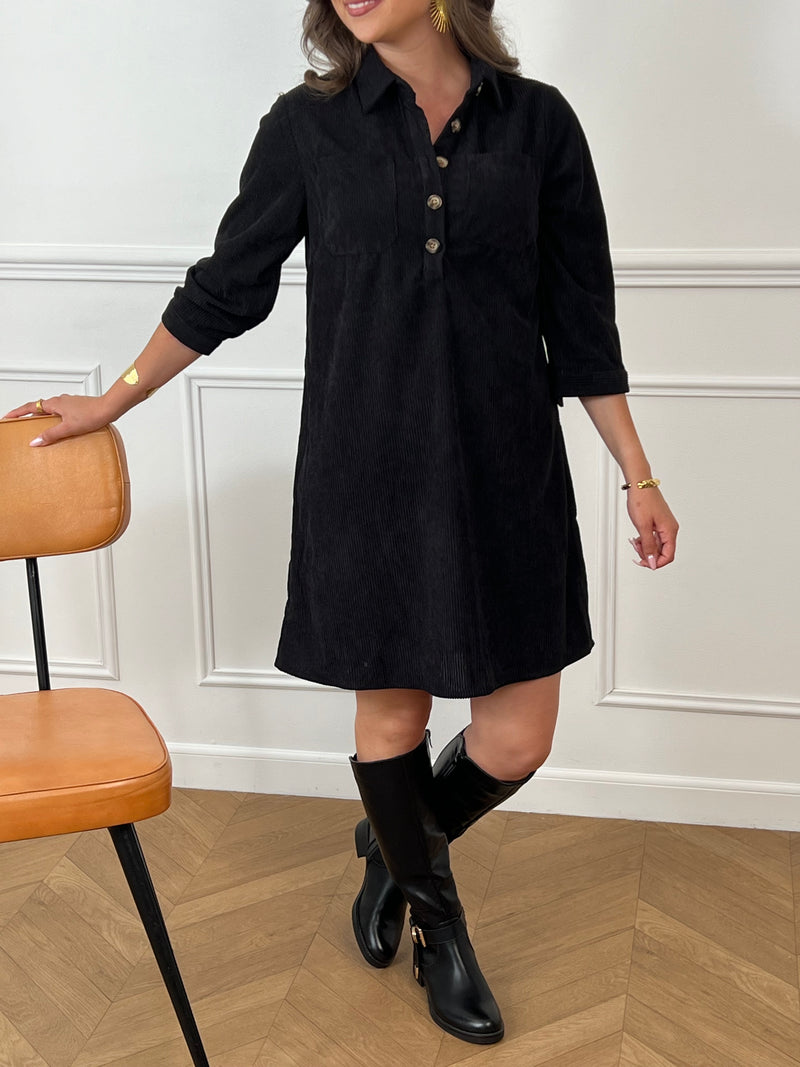 Cette robe courte noire, modèle Cora, allie élégance et confort. Ses manches longues et son col chemise apportent une touche sophistiquée, tandis que les boutons au col et aux manches accentuent son style raffiné.