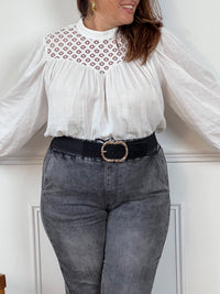 Cette blouse écrue en 100% coton pour femme allie élégance et raffinement avec ses détails ajourés et ses broderies délicates. Conçue avec des manches longues et un col rond, elle présente un bouton discret au dos pour une touche d'originalité. La blouse est doublée à l'avant pour un confort optimal, tandis que les détails ajourés ajoutent une note de sophistication. Sa teinte écrue douce et naturelle s’accorde facilement avec différents styles, idéale pour un look chic et intemporel. Cette blouse en coton 