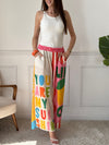 Ce pantalon en lin aux motifs colorés et inspirés des vacances respire la bonne humeur. Avec ses inscriptions comme "You are my Sunshine", "Lemoncello" ou "You are the Sunshine in everyday", il invite à la détente et à l’évasion. Ses teintes de beige, vert, orange, rose, rouge et bleu en font une pièce pétillante, idéale pour un look estival plein de charme et de légèreté.