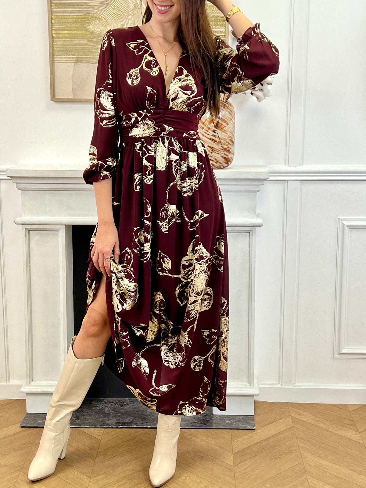 Robe longue bordeaux élégante aux détails dorés, idéale pour les occasions spéciales. Son col V et ses manches longues apportent une touche raffinée, tandis que l’élastique au dos assure un confort parfait. Entièrement doublée jusqu’à mi-longueur, elle allie style et aisance dans des nuances subtiles de bordeaux et doré.