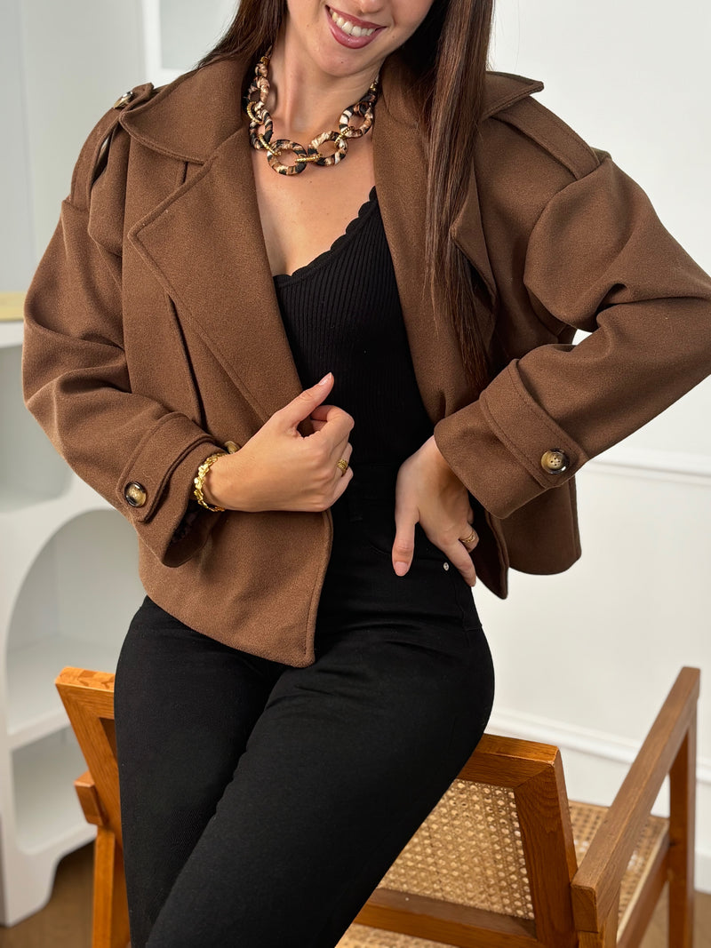 Veste Athenais, coupe courte et droite avec manches longues et col à revers. Doublée pour plus de confort, sans poches. Fermeture par boutons. Élégante en marron, elle allie simplicité et fonctionnalité.