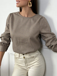 Un incontournable à ajouter à votre dressing ! Cette blouse à carreaux, avec son col V élégant et ses manches longues, offre une allure moderne et féminine. La fente subtile sur le devant, accompagnée de ses boutons raffinés au niveau du décolleté et des poignets, lui donne une touche de caractère. Idéale pour une tenue chic et décontractée, elle s'accorde aussi bien avec un jean qu'une jupe crayon