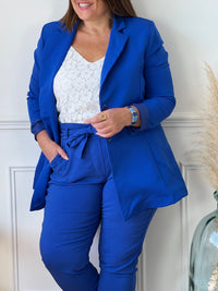 Ce blazer bleu roi grande taille pour femme est un must-have pour toute garde-robe! Fabriqué en Italie, il dispose d'une doublure et de manches longues avec épaulettes pour une silhouette élégante et structurée. Les boutons sur la longueur ajoutent une touche de sophistication et les poches factices à l'avant offrent un supplément de style.