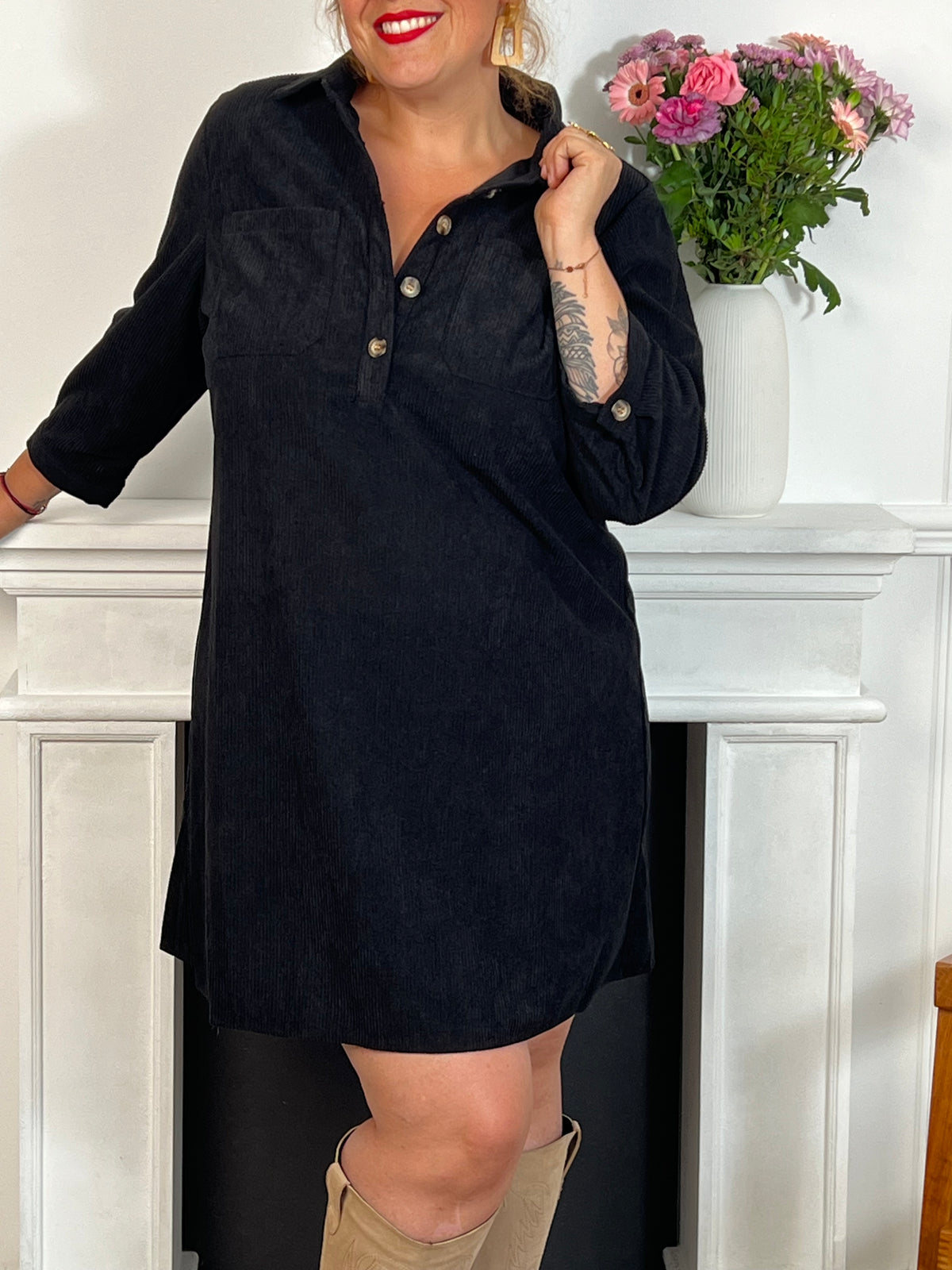 Cette robe courte noire grande taille, modèle Cora, allie élégance et confort. Ses manches longues et son col chemise apportent une touche sophistiquée, tandis que les boutons au col et aux manches accentuent son style raffiné.