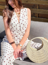 Ensemble femme élégant composé d’un top sans manches à col cache-cœur avec lien à la taille et d’un pantalon fluide assorti à pois. Sa teinte beige à pois marron apporte une touche chic et intemporelle. Fabriqué en Italie, cet ensemble est idéal pour un look raffiné au quotidien.