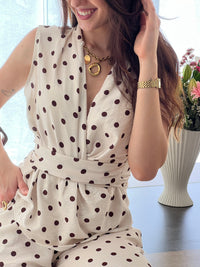 Ensemble femme élégant composé d’un top sans manches à col cache-cœur avec lien à la taille et d’un pantalon fluide assorti à pois. Sa teinte beige à pois marron apporte une touche chic et intemporelle. Fabriqué en Italie, cet ensemble est idéal pour un look raffiné au quotidien.