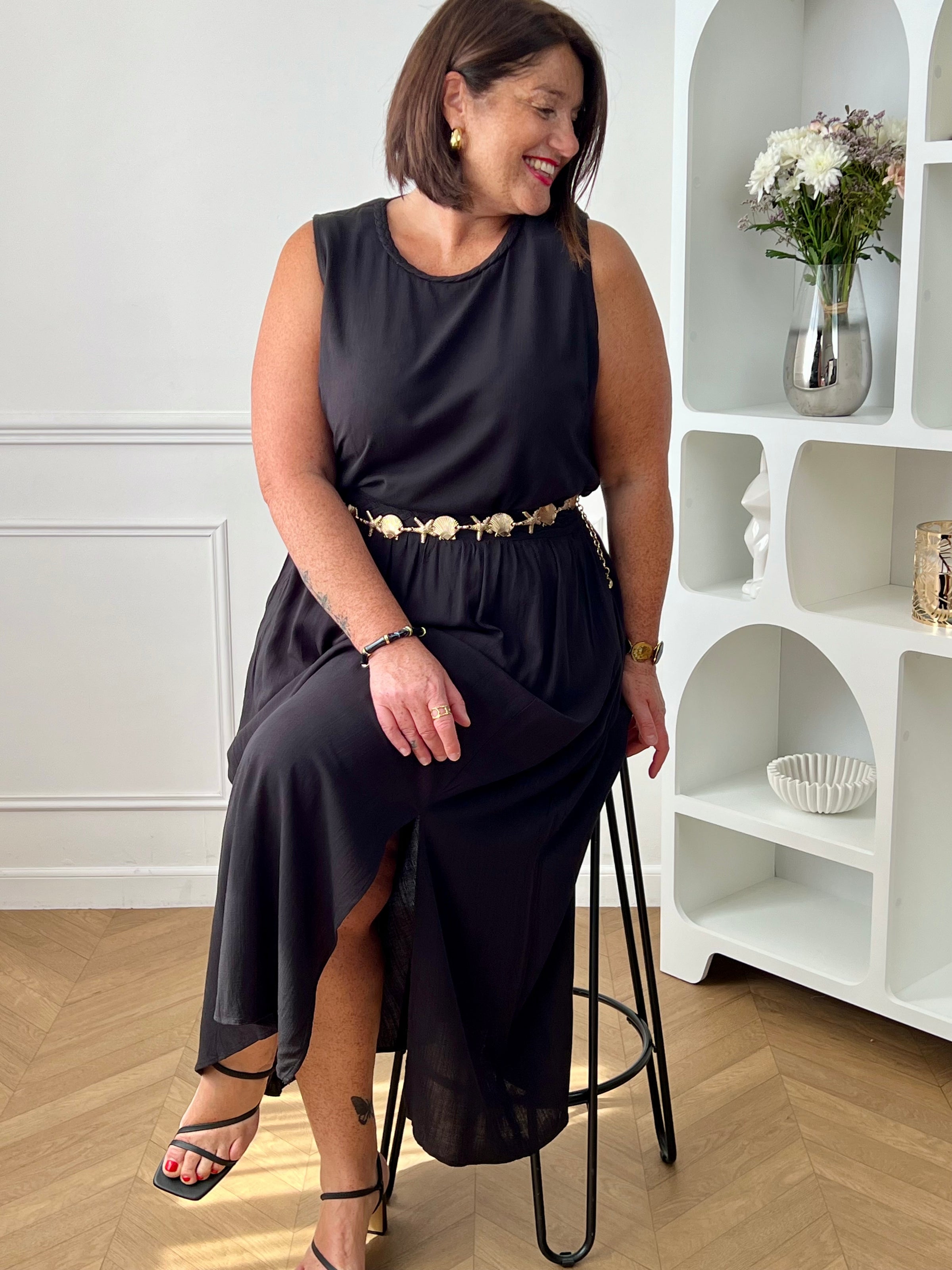 Craquez pour cet ensemble blouse et jupe noire grande taille au style élégant et raffiné. La jupe longue à coupe fluide se distingue par sa fente sur le côté, sa tresse à la taille et son élastique au dos pour un confort optimal. La blouse sans manches, dotée d’un col rond avec détail tressé et d’une ouverture au dos avec bouton, apporte une touche féminine et sophistiquée.