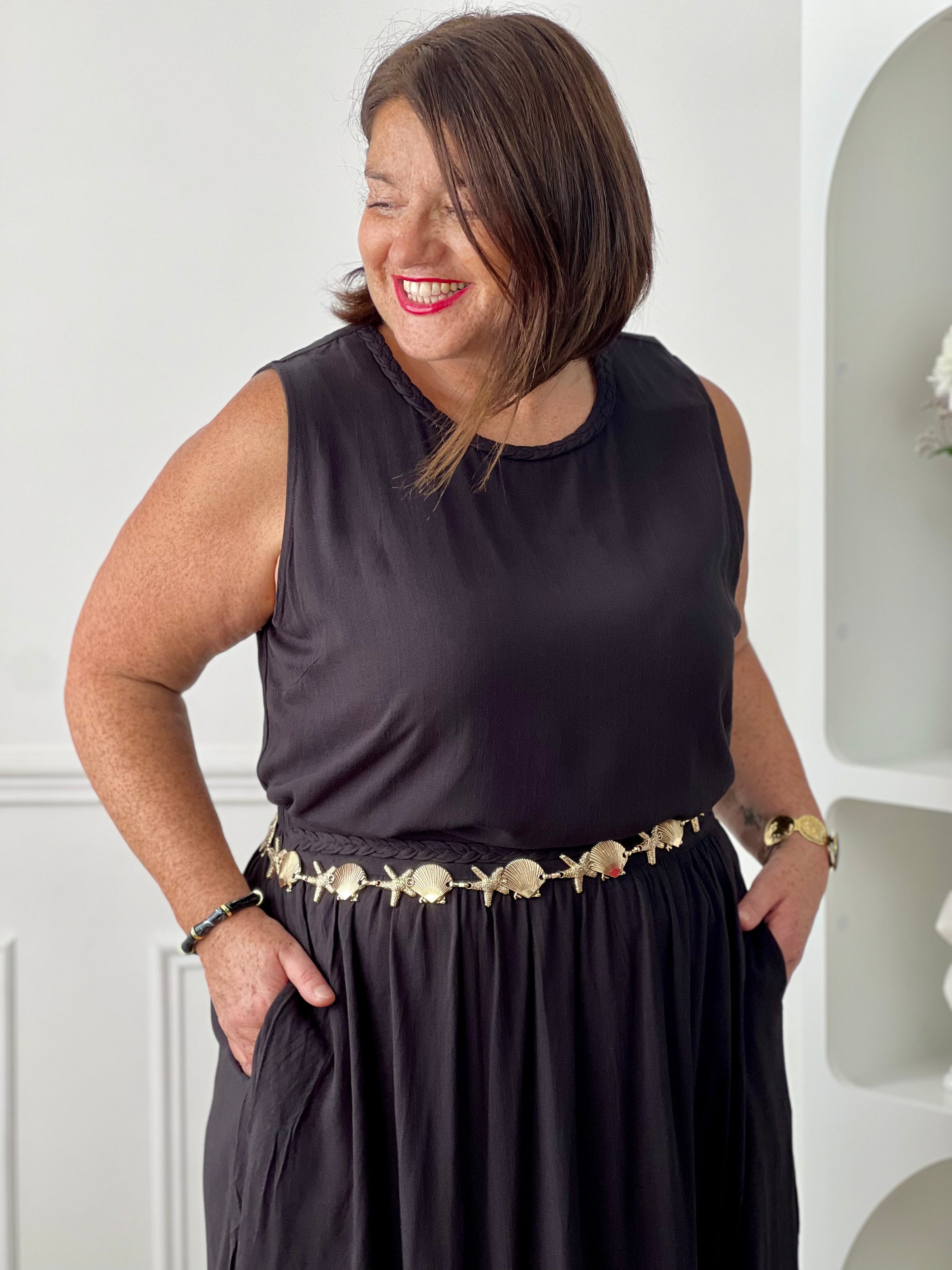 Craquez pour cet ensemble blouse et jupe noire grande taille au style élégant et raffiné. La jupe longue à coupe fluide se distingue par sa fente sur le côté, sa tresse à la taille et son élastique au dos pour un confort optimal. La blouse sans manches, dotée d’un col rond avec détail tressé et d’une ouverture au dos avec bouton, apporte une touche féminine et sophistiquée.
