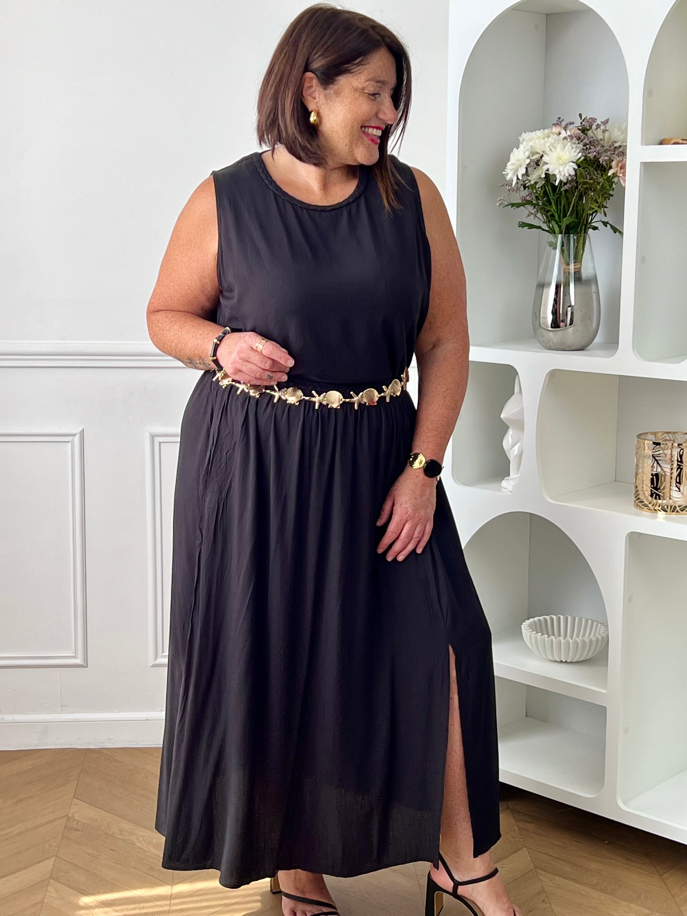 Craquez pour cet ensemble blouse et jupe noire grande taille au style élégant et raffiné. La jupe longue à coupe fluide se distingue par sa fente sur le côté, sa tresse à la taille et son élastique au dos pour un confort optimal. La blouse sans manches, dotée d’un col rond avec détail tressé et d’une ouverture au dos avec bouton, apporte une touche féminine et sophistiquée.